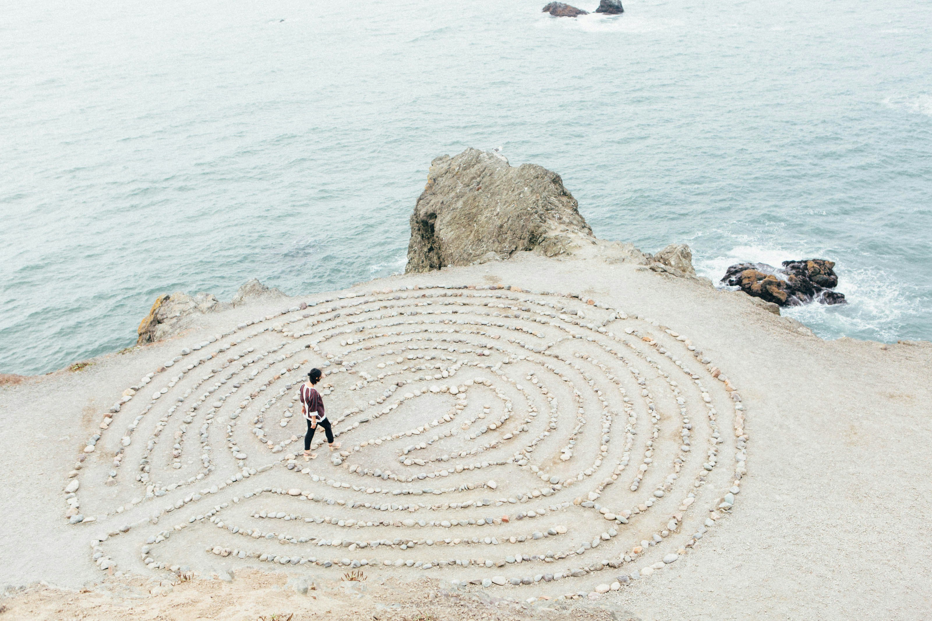 Personne marchant dans un labyrinthe face à la mer